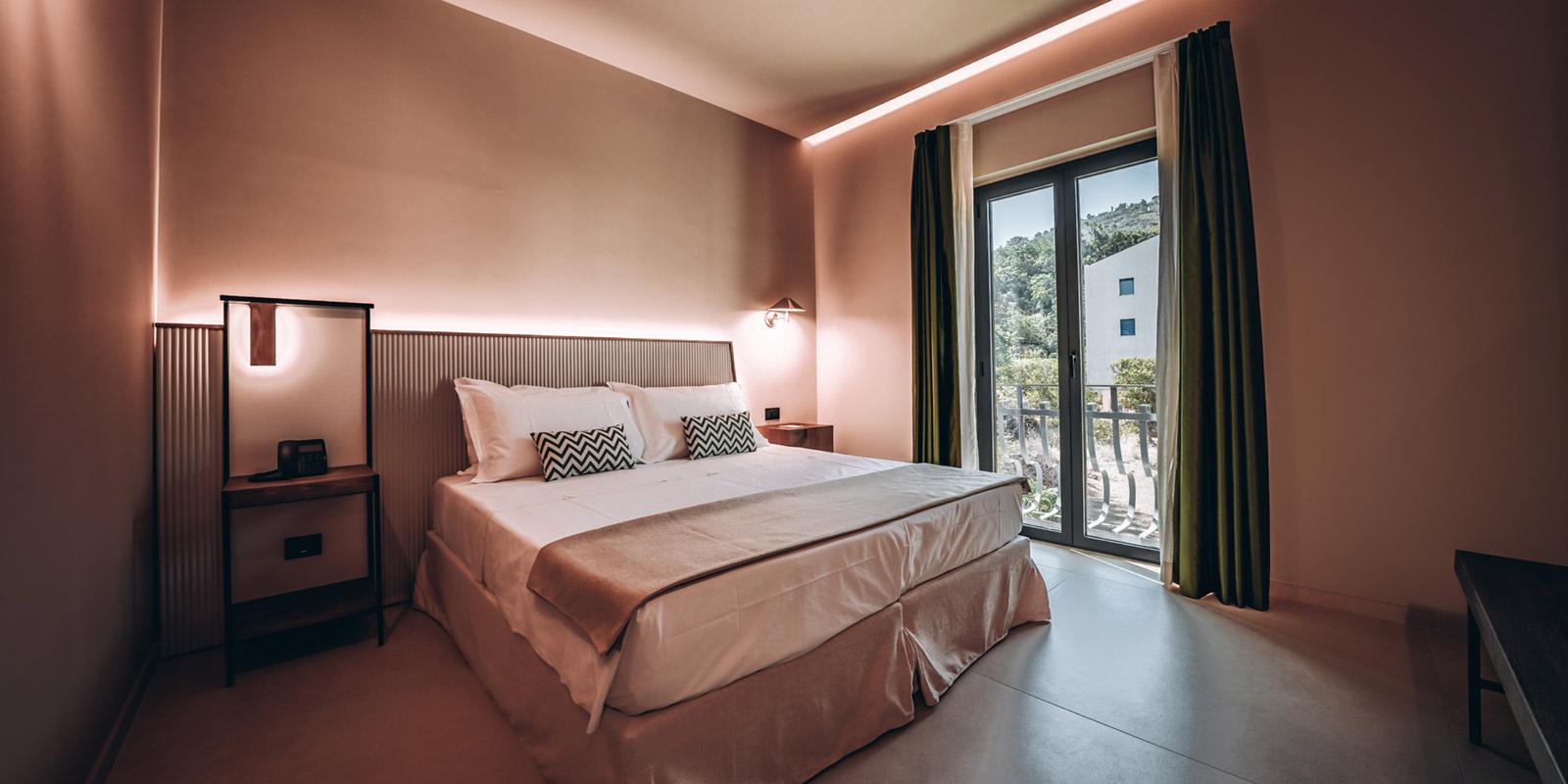 Camera da letto moderna con letto matrimoniale e finestra con vista esterna.
