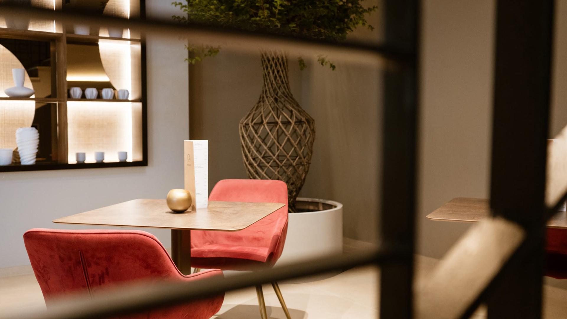 Interno elegante con sedie rosse, tavolo e decorazioni moderne.